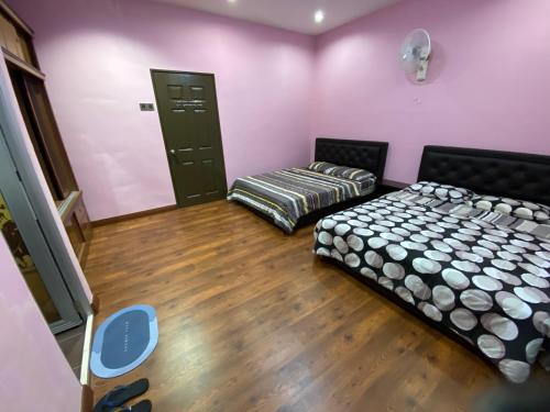 丹那拉打Frosty Hills Homestay的配有粉红色墙壁和木地板的客房内的两张床