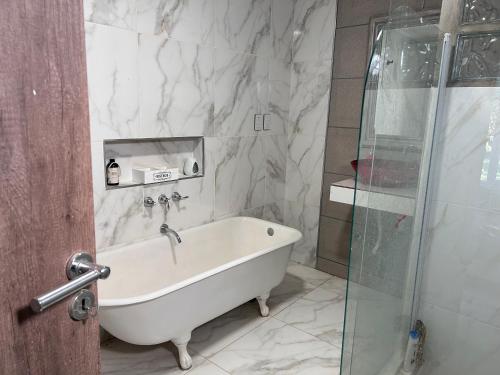 罗卡将军市General Roca hermosa habitacion con baño privado的带浴缸和玻璃淋浴间的浴室。