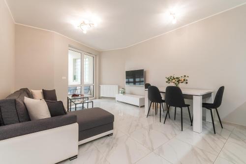 詹塔尔Flatbook Apartamenty - Jantar Bursztynowe Osiedle的客厅配有沙发和桌椅