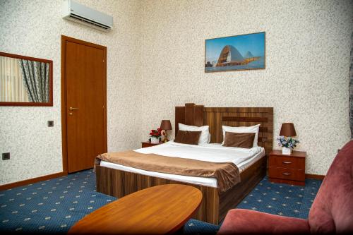 巴库Port Hotel Baku的配有一张床和一把椅子的酒店客房