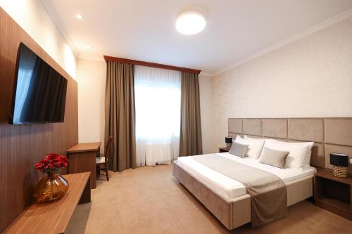 巴尼亚卢卡维多维奇酒店的酒店客房,配有床和电视