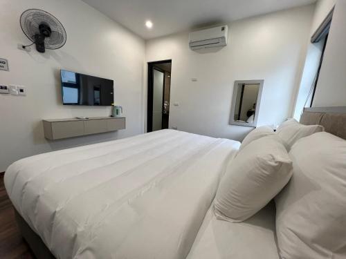 河内Grand Dragon Noi Bai Hotel的白色卧室设有一张大床和一台平面电视。