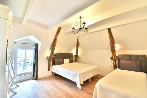 SainsGite Mont Saint Michel "AUCOEURDELABAIE"的一间卧室配有两张床和镜子