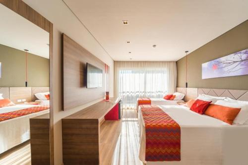 格拉玛多Hotel Laghetto Stilo Borges的一间酒店客房,设有两张床和电视