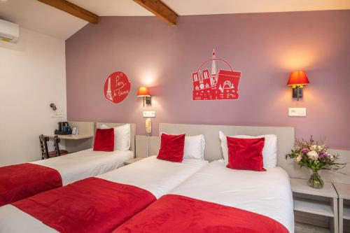 巴黎圣乔治拉法耶特酒店的两张位于酒店客房的床铺,配有红色枕头