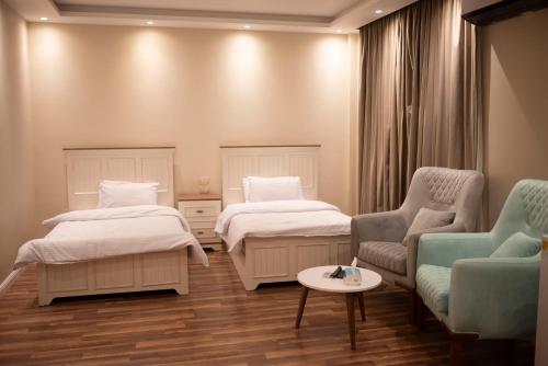 开罗Munir’s residence的客房设有两张床、一张沙发和一张桌子。