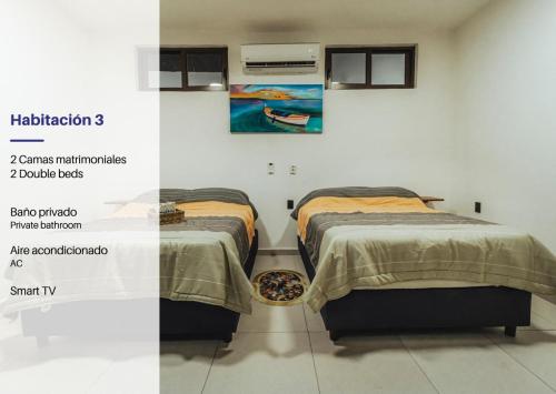 拉曼萨尼亚Discover La Manzanilla: New Natural Haven for Adventure的墙上画画的房间里设有两张床