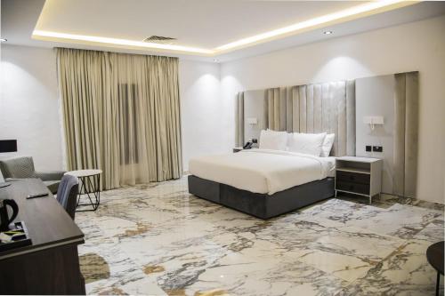 拉各斯The Safron Hotel的配有一张床和一张书桌的酒店客房