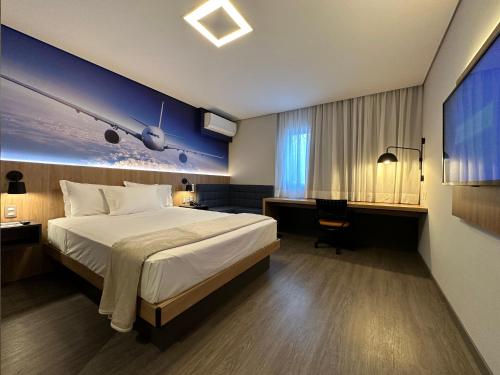 瓜鲁柳斯帕纳比瓜鲁柳斯酒店的酒店客房设有一张大床和一张书桌。