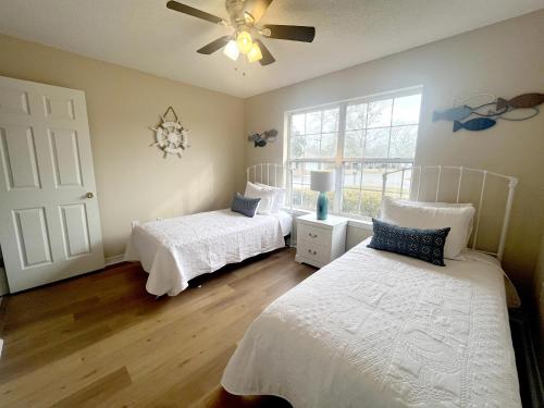 弗利Entire home in Foley, Alabama, United States的一间卧室配有两张床和吊扇