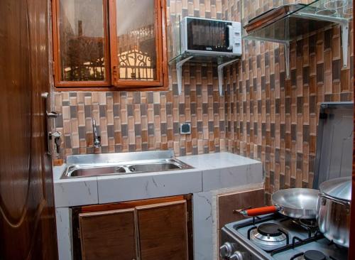瓦加杜古Passion RÉSIDENCE的厨房配有水槽和炉灶