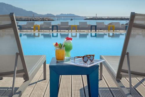 马赛马赛豪酒店的一张蓝色桌子,上面有饮料和眼镜