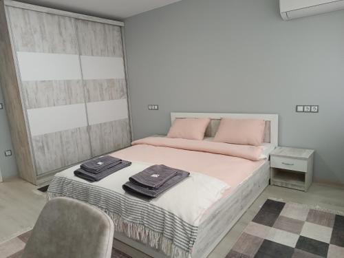 戈采代尔切夫City Apartment的一间卧室配有带粉红色枕头的床。