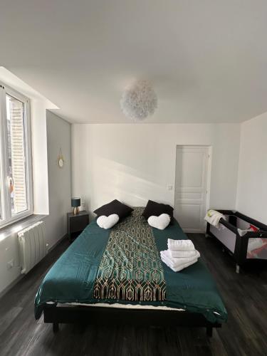 Saint-Germain-des-FossésAppart cocooning的一间卧室配有带两个枕头的绿色床