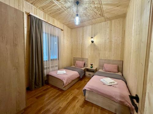 塞凡Milenium magic villa on Sevan beach的配有木墙和木地板的客房中的两张床