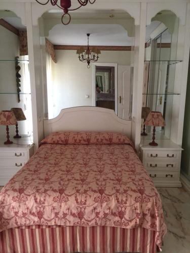 科尔多瓦Gran piso familiar的一间卧室配有一张大床和粉红色的床罩