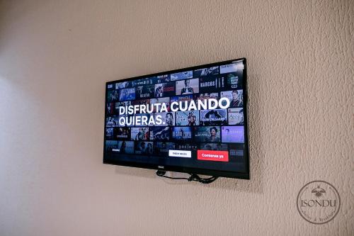 伊瓜苏港ISONDU Suites & Breakfast的挂在墙上的平面电视