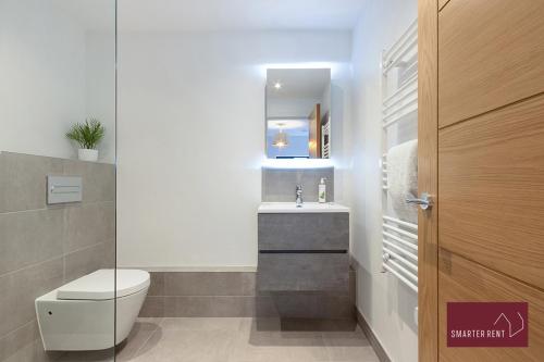 沃金厄姆Modern 3 Bedroom Apartment - Wokingham的一间带卫生间、水槽和镜子的浴室