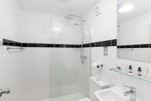 布罗德福德都诺丽酒店‘定制酒店’的带淋浴和盥洗盆的白色浴室