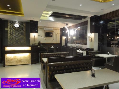 孟买Hotel Naaz Executive的一间带桌椅的餐厅和一间厨房