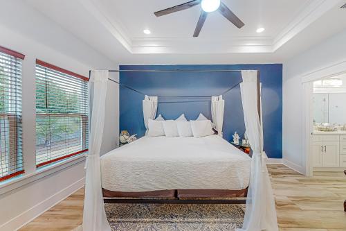 巴拿马城海滩Driftwood Dreams的一间卧室配有一张蓝色墙壁的床