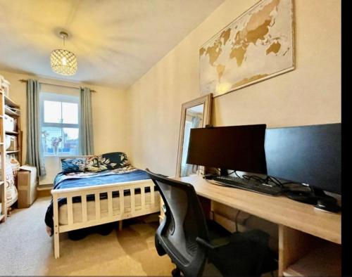 泰晤士河畔金斯顿Cosy 2 bedroom appartment with gated parking by River Thames的一间卧室配有一张桌子、一台电脑和一张床