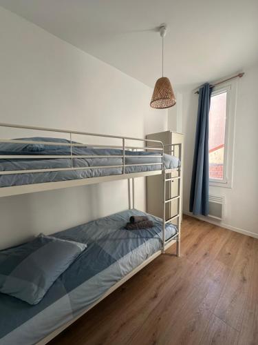 土伦Le Mourillonnais的一间卧室设有两张双层床和吊灯。