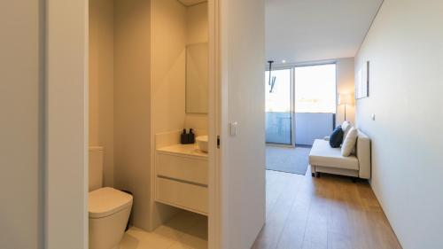 Senhora da HoraNice Circunvalação Studio II By Unique Hosts的一间带卫生间、水槽和沙发的浴室