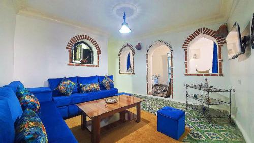 舍夫沙万Dar La Aicha的客厅配有蓝色的沙发和桌子