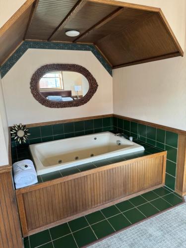 FennimoreFenway House Hotel的浴室铺有绿色瓷砖,配有浴缸。