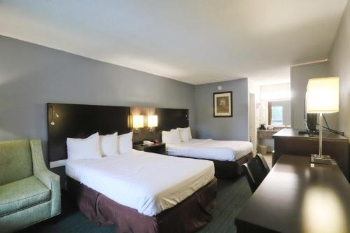 格林维尔格林维尔酒店的酒店客房,配有两张床和椅子