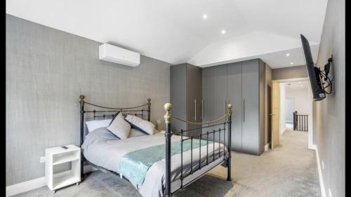 East BarnetNewly refurbished 3 bedroom property in north london的一间卧室配有一张床和一台电视。