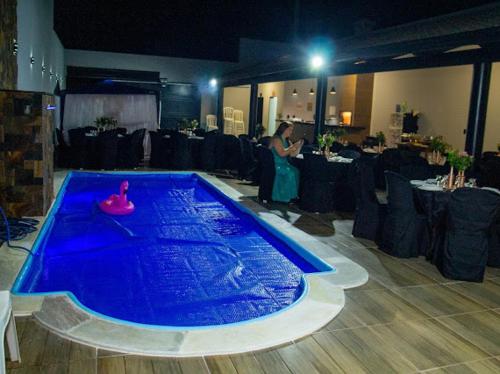 乌贝拉巴Casa de lazer km eventos的站在一个蓝色泳池旁的女人