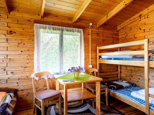 卡尔维亚O.W. Sęk的小屋内设有一间带桌子和双层床的卧室