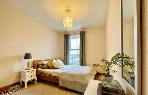 泰晤士河畔金斯顿Cosy 2 bedroom appartment with gated parking by River Thames的一间卧室设有一张床和一个大窗户