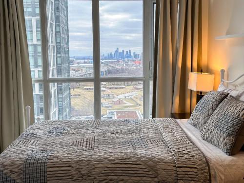 多伦多300 Front Suites - Two Beds with Free Parking的一间卧室设有一张大床和一个大窗户
