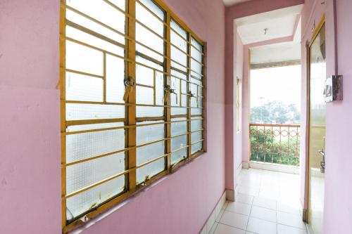 贾姆谢德布尔OYO Hotel Suvidha的一间设有粉红色墙壁和大窗户的客房