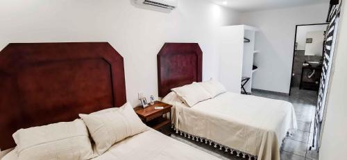 Cuatrociénegas de CarranzaVagón Resort的一间卧室设有两张床和木制床头板