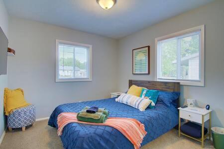 北坎顿Cozy Updated Home W Rec Room & Large Backyard的一间卧室设有蓝色的床和2个窗户。