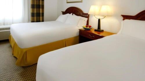 伊格尔Wingate by Wyndham Eagle Vail Valley的酒店客房设有两张床和一张带台灯的桌子。