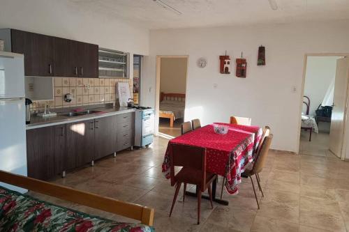 里奥格兰德Casa de Praia Extremo Sul的厨房以及带红色桌椅的用餐室。