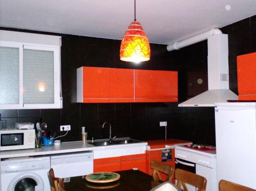AlomartesEl Mirador de Pablo, casa con patio privado的厨房配有橙色橱柜和安达灯