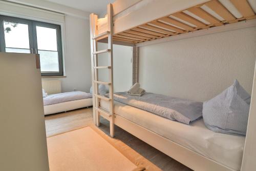 朗格奥Süderdüne的一间卧室设有两张双层床和梯子