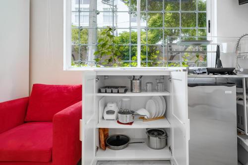 墨西哥城Leib 65的白色厨房里的红色沙发,带有窗户