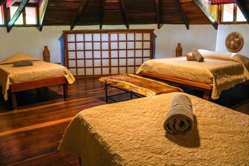 塔马林多Hotel Boruca Tamarindo的带三张床的房间
