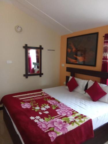 乌提Queenhill Homestay Ooty的一间卧室配有一张带红色毯子的床