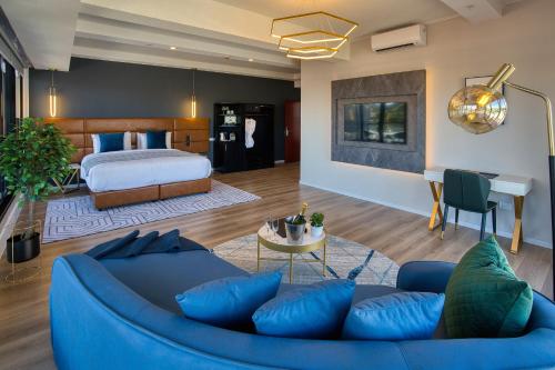 奥克兰SOHO Hotel Auckland的客厅配有蓝色的沙发和床。