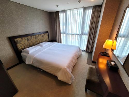 釜山W Residence Hotel Centum City的卧室配有白色的床和窗户。