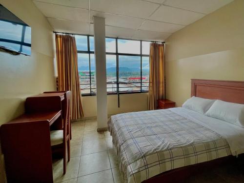 特纳Hotel Río Tena的一间卧室配有一张床、一张书桌和一个窗户。