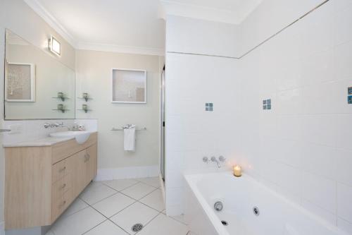 汤斯维尔Breakwater 13的白色的浴室设有浴缸和水槽。